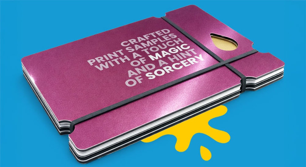 Stack of purple print samples with white text, held by a black band on a blue background.