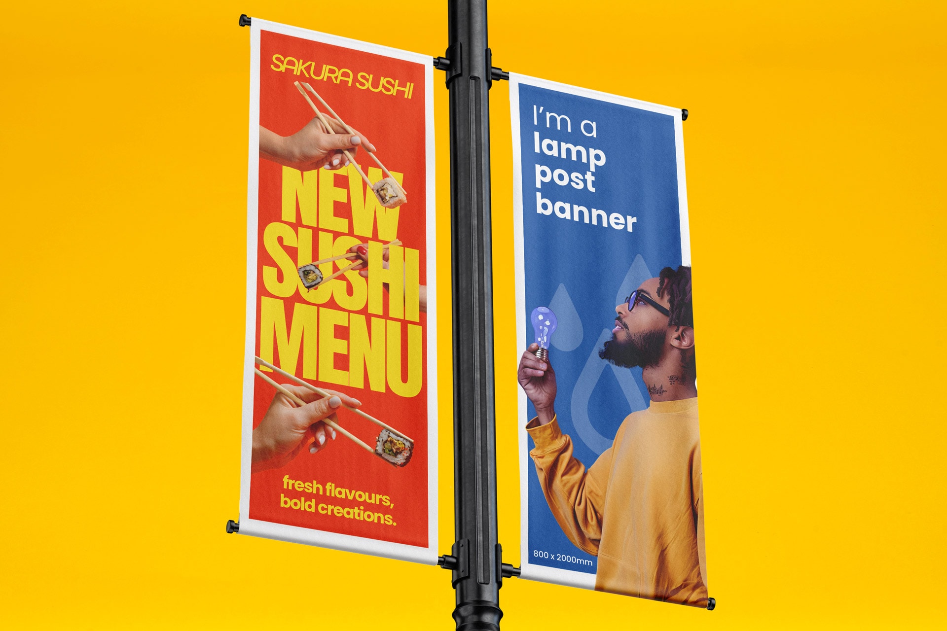 Two vertical banners on a lamp post; one advertises sushi, the other displays a sample banner.
