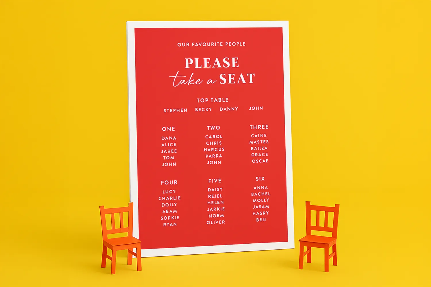 A red seating chart with six table assignments stands between two small orange chairs.
