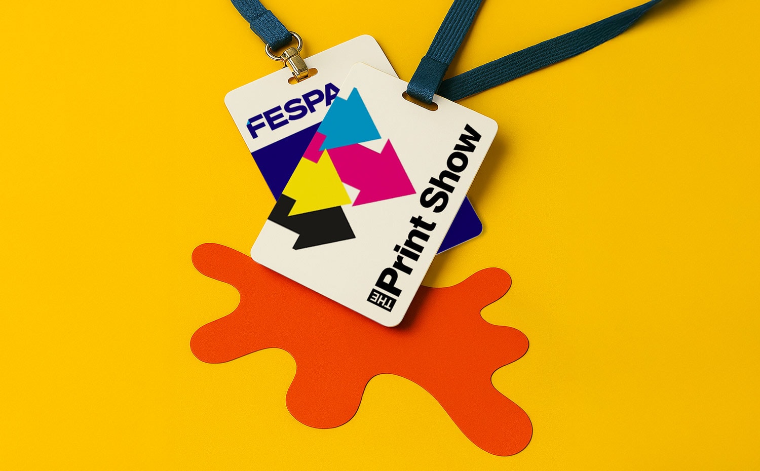 Two event badges with lanyards on a yellow background with an orange splash-shaped cutout.