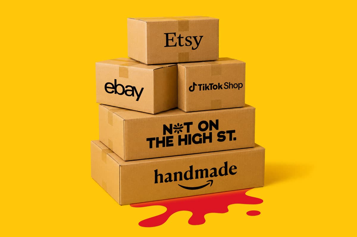 Five branded cardboard boxes stacked on a yellow background with a red paint spill underneath.