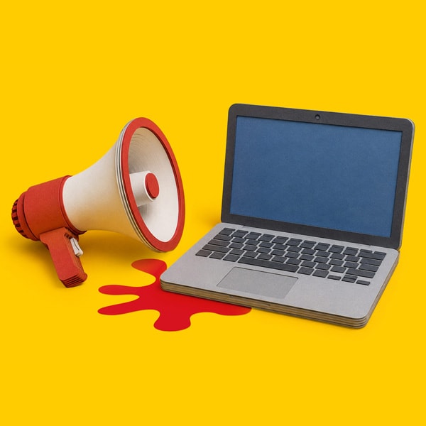 A laptop and a megaphone sit on a yellow background with a red splash shape nearby.