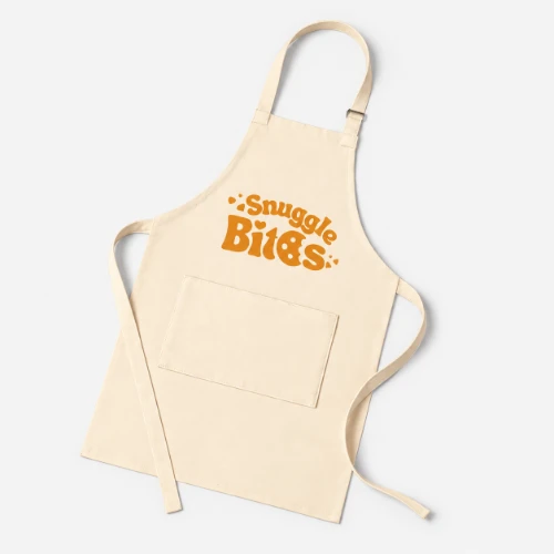 Beige apron with “Snuggle Bits” printed in orange text above a front pocket.