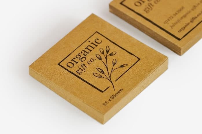 Square brown paper card with "organic gift co." and a simple plant illustration printed on it.