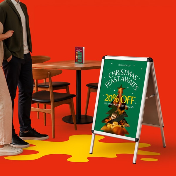 A sign advertises 20% off for a Christmas feast; two people stand by a table in the background.