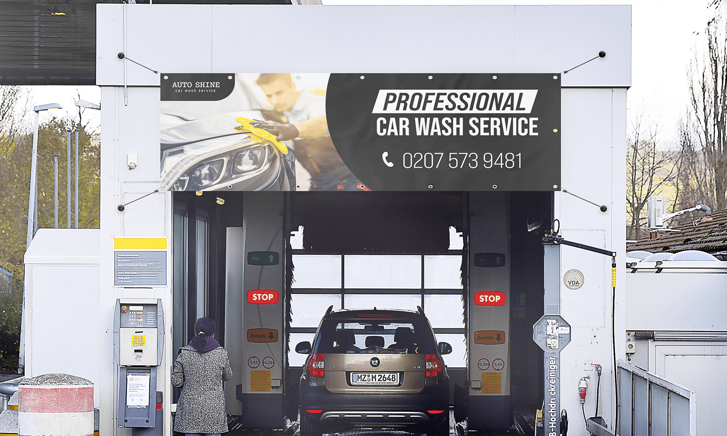 A car enters an automated car wash with an advertising banner reading "Professional Car Wash Service".