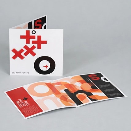 Two folded brochures with bold, overlapping black and red letters on a grey background.