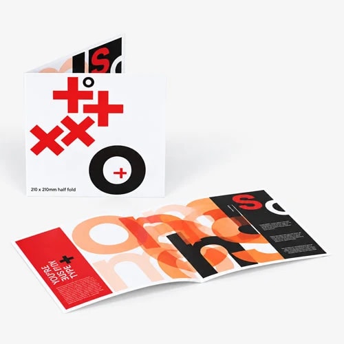 Two folded brochures with bold, overlapping black and red letters on a grey background.