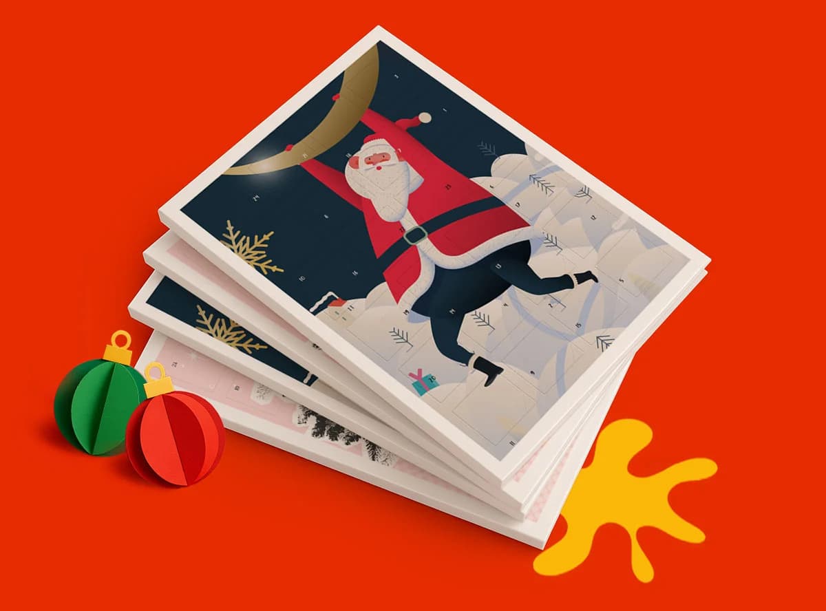 Stack of Christmas Advent Calendars with a Santa illustration, ornaments, and a yellow shape on red background.
