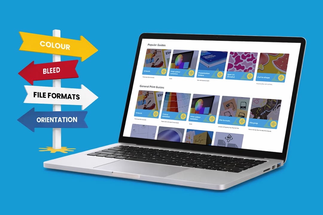 A laptop displaying print guides, next to a colourful signpost with print-related terms.