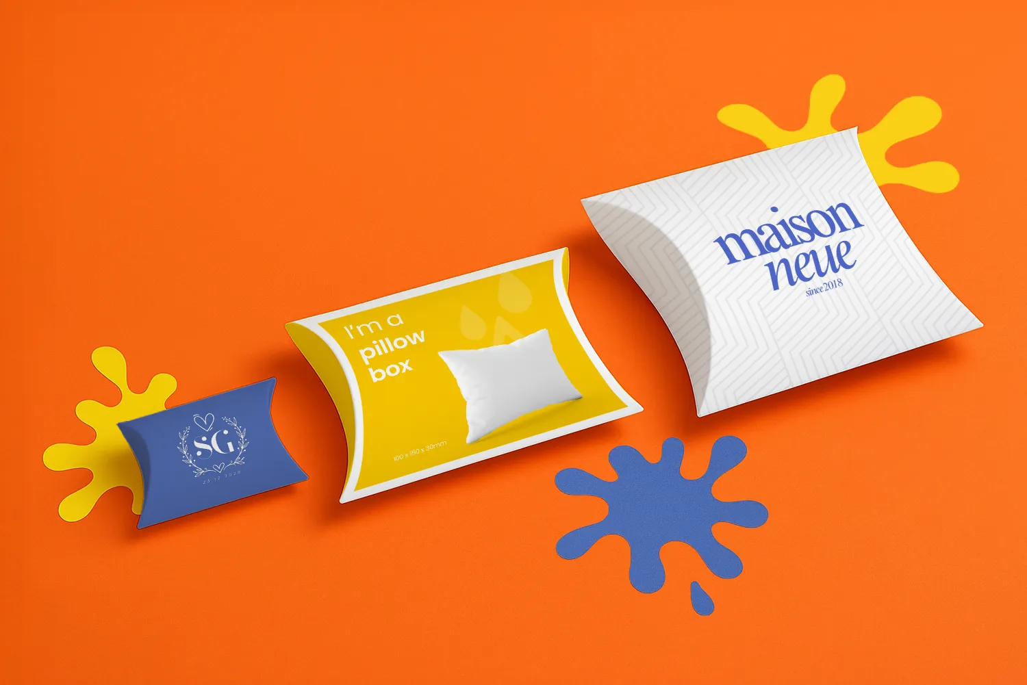 Three pillow boxes of different sizes on an orange background with blue and yellow splashes.