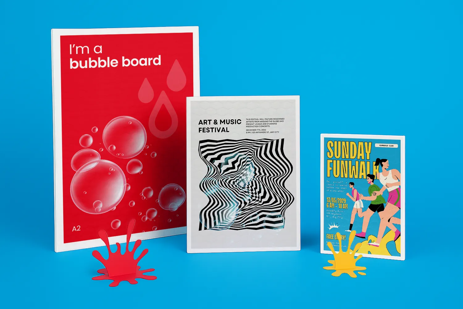 Three colourful event signs stand upright against a blue background with paint splatters in front.