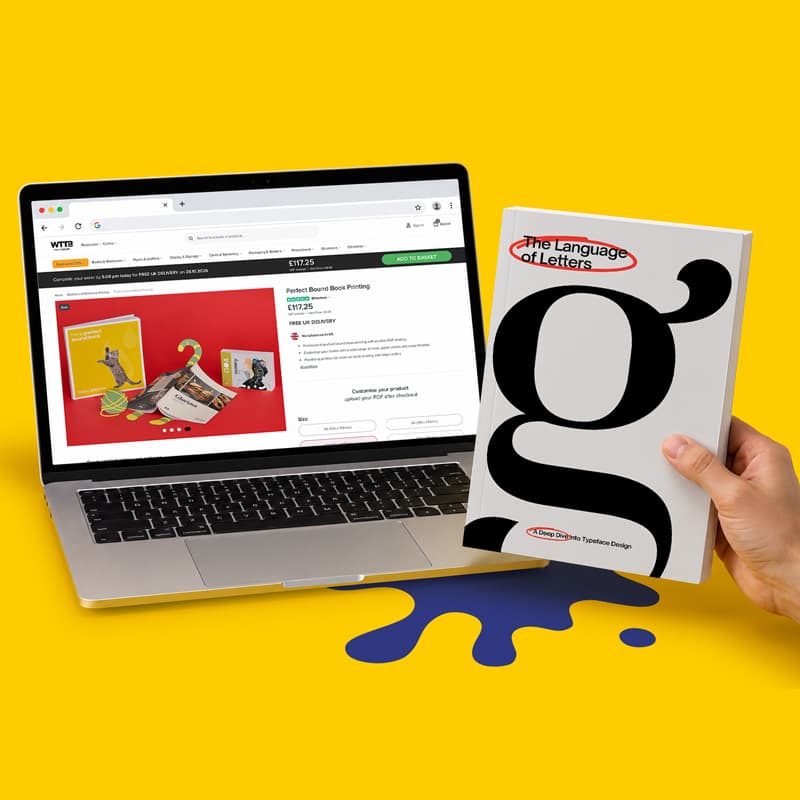 A laptop showing a printing website next to a book titled “The Language of Letters.”