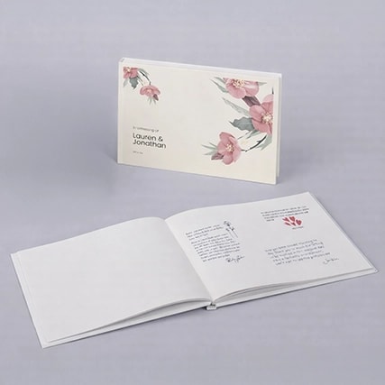 Two floral-themed books, one closed and one open, displayed on a light gray surface.