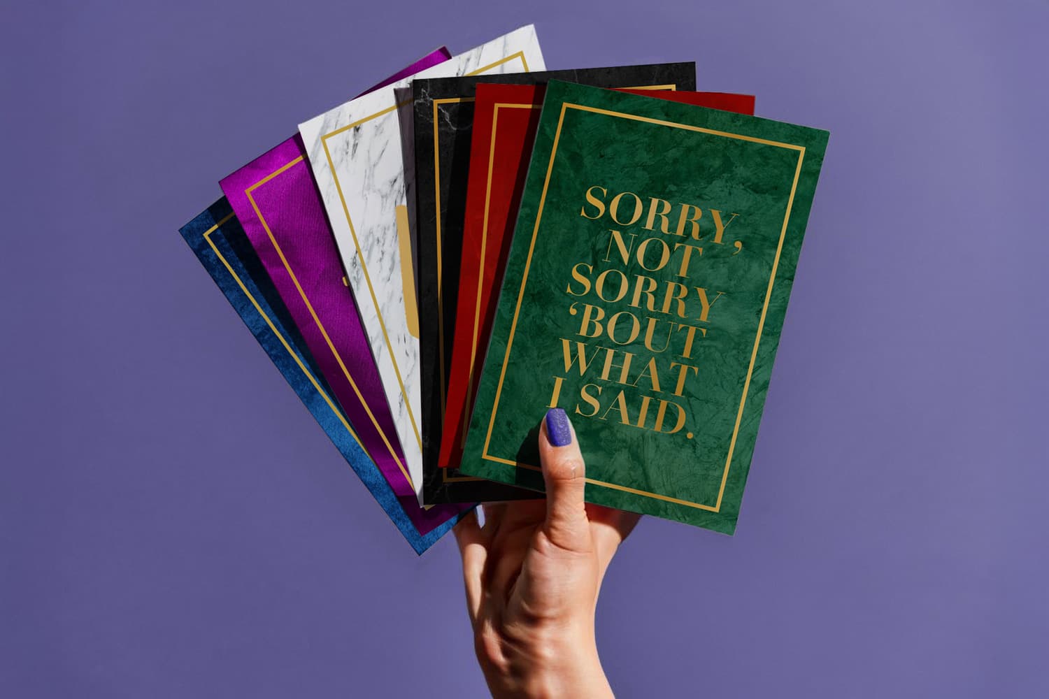 A hand holds colourful cards, one reading "SORRY, NOT SORRY 'BOUT WHAT I SAID.