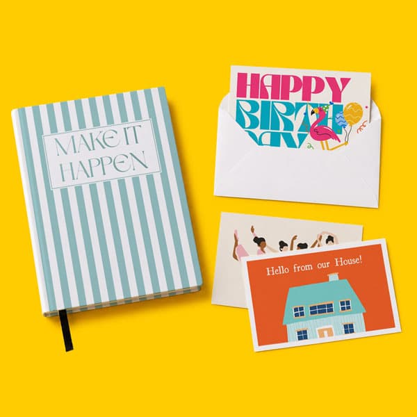Striped notebook and three greeting cards on a yellow background.