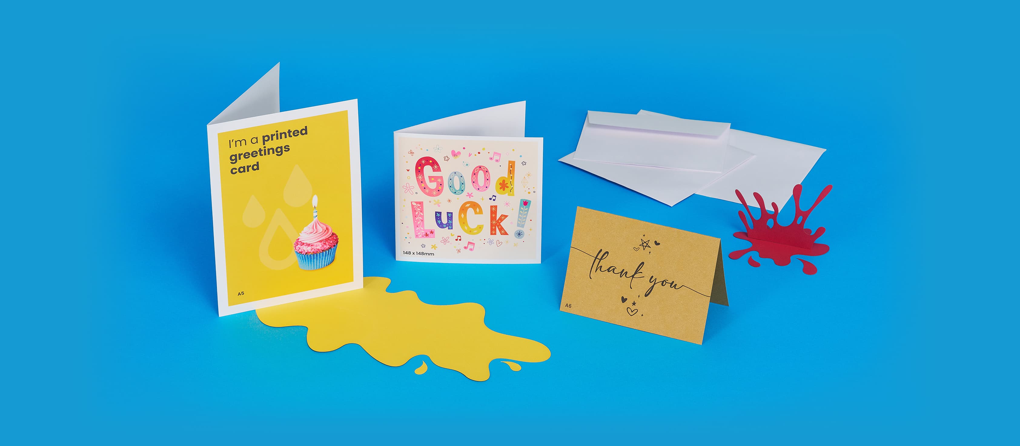 Greeting cards displayed on a blue background with colorful splashes and envelopes.