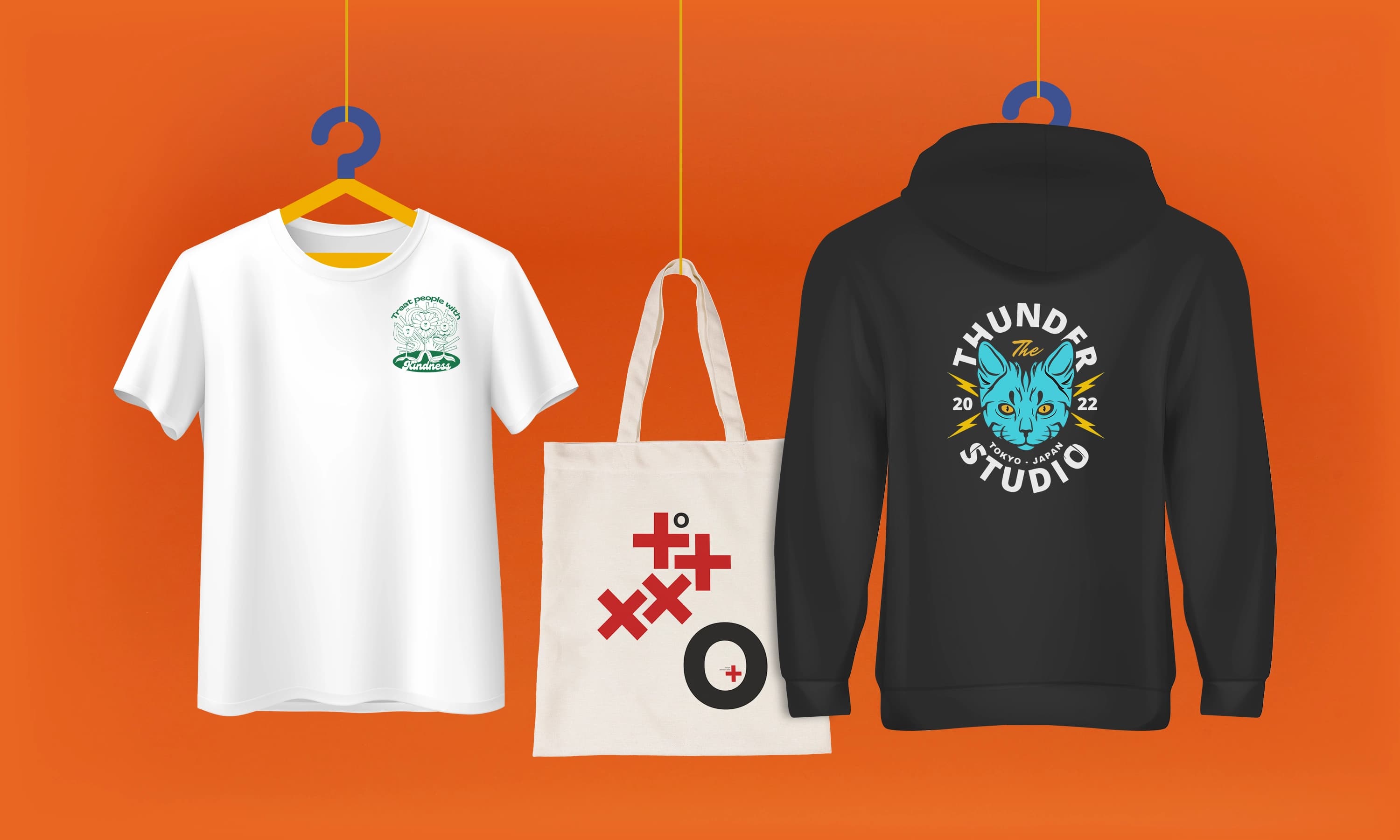 White t-shirt, canvas tote bag, and black hoodie with designs on an orange background.