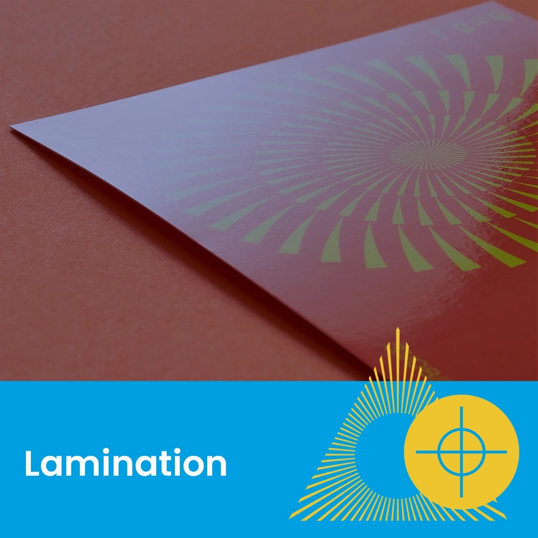 A gloss laminated paper with a yellow and green spiral design on a reddish surface.