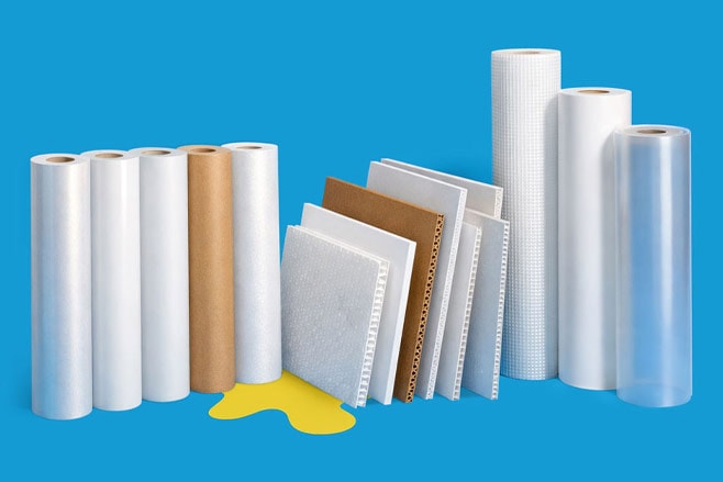 Assorted rolls of packaging material and sample sheets displayed upright on a blue background.