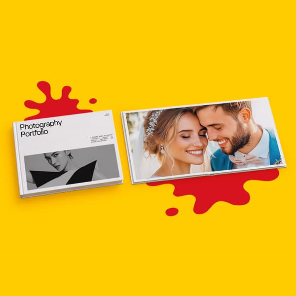 Two photography books on a yellow surface with red paint splatters underneath each book.