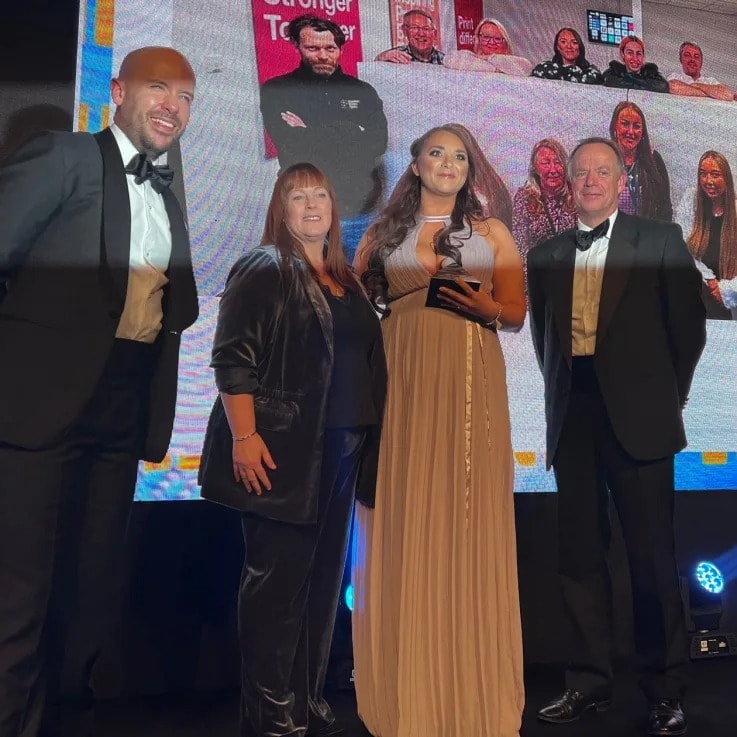 Team members from WTTB receive an award on stage, recognising their excellence in customer service.