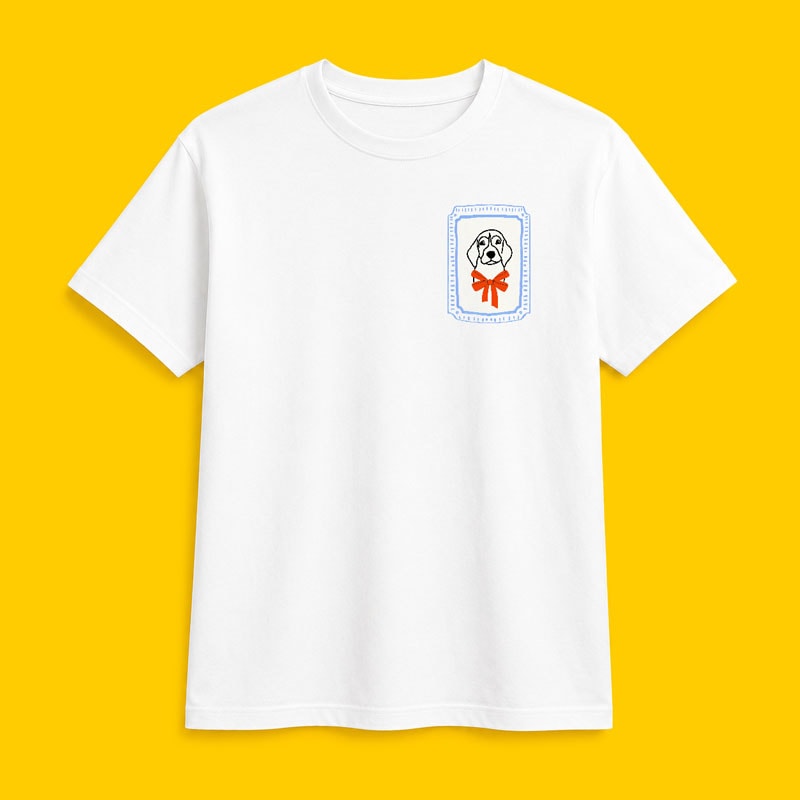 White t-shirt with a small dog face graphic and red bow printed on the left chest.