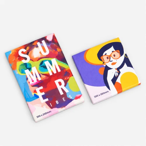Two colourful, canvas prints with abstract summer-themed cover designs on a grey surface.
