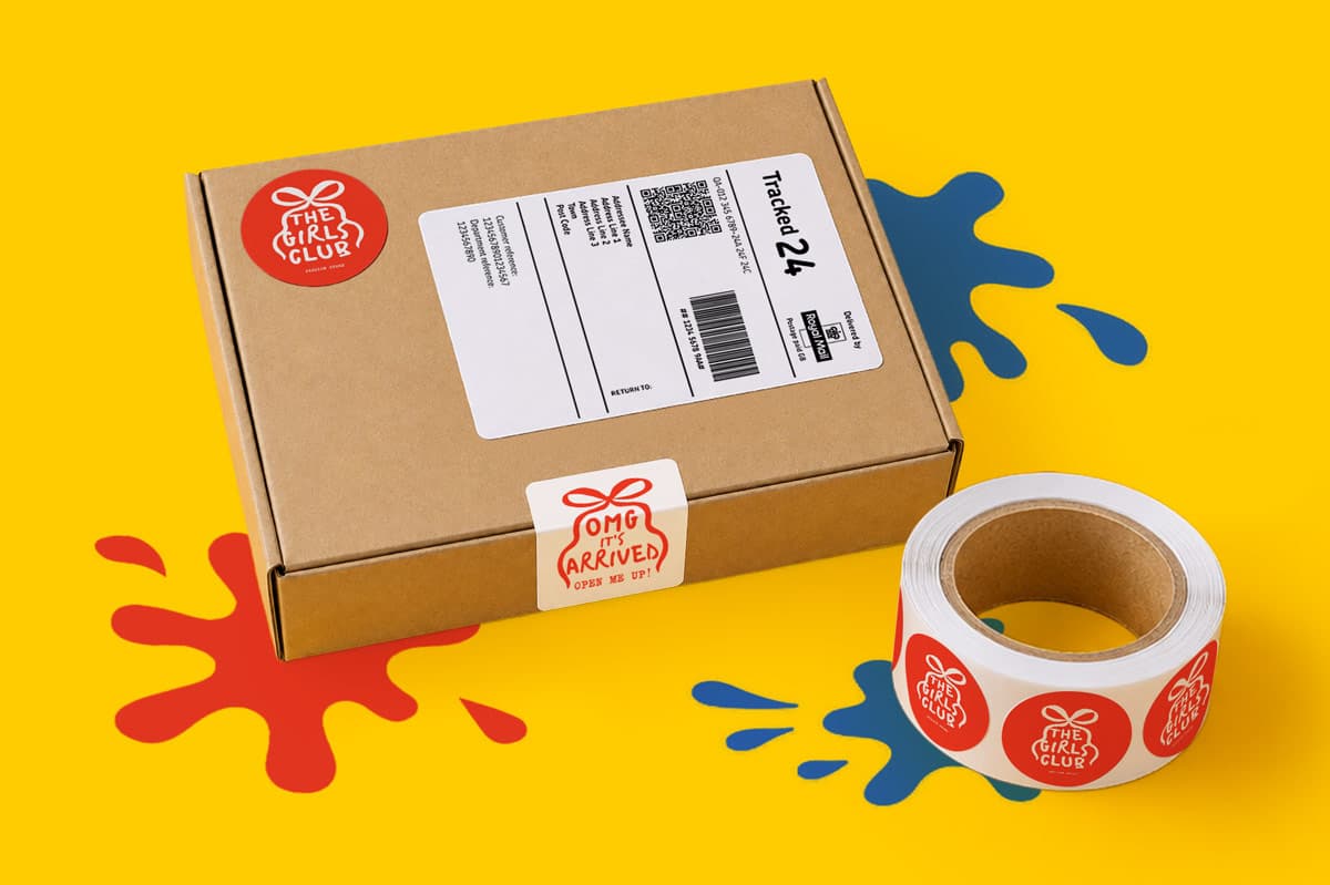 Brown shipping box with a red sticker, next to a roll of similar stickers on a yellow background.