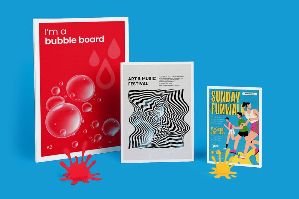 Three colorful poster prints displayed upright against a blue background with paint splash cutouts.