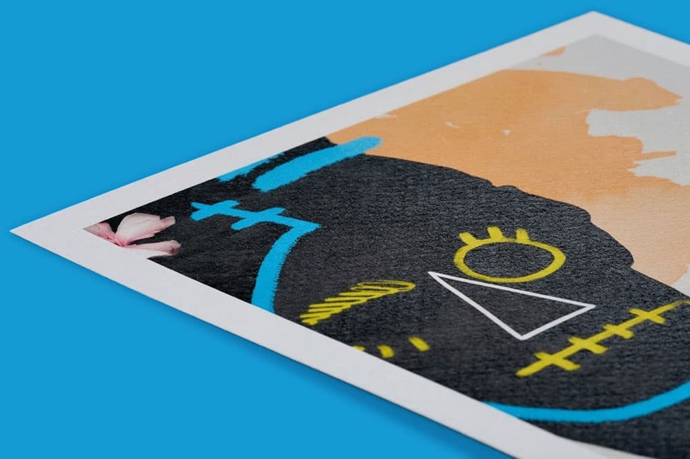 Close-up of a colourful abstract skull illustration on paper against a solid blue background.