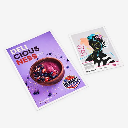 Two printed bus shelter posters on a flat surface, one with food and one with abstract art and event details.