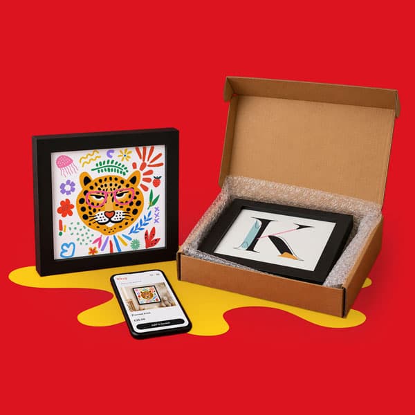 Framed art prints, a smartphone, and a box with bubble wrap on a red background.
