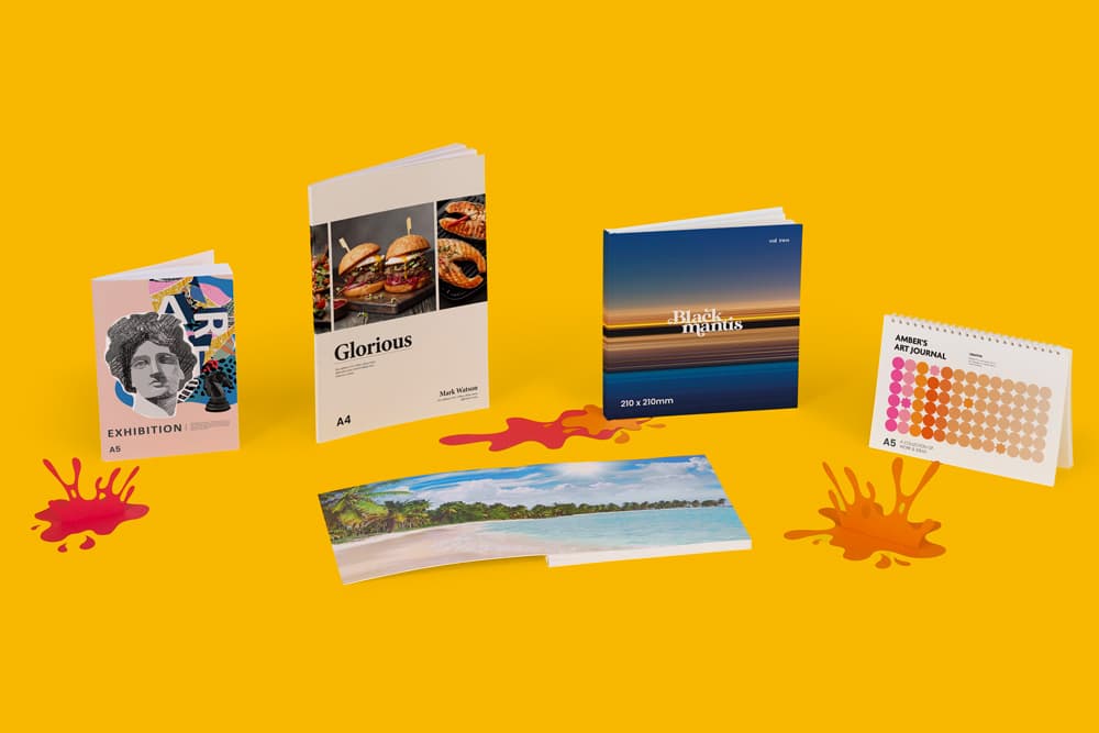 Four printed publications and a landscape photo book arranged on a yellow background.
