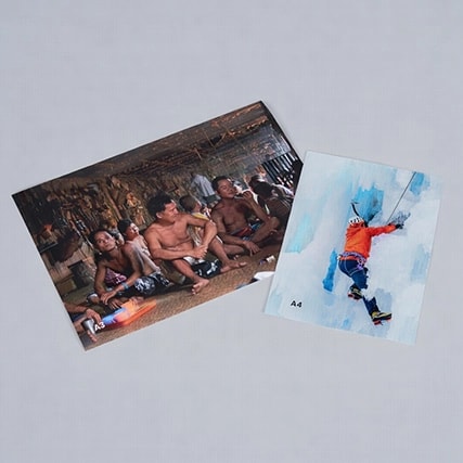 Two A4 prints: one of a group indoors, the other of a person climbing on ice.