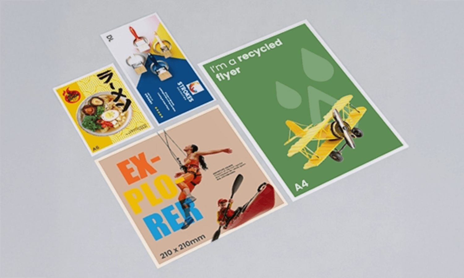 Five colourful flyers with various designs and images arranged on a wide, light grey surface.