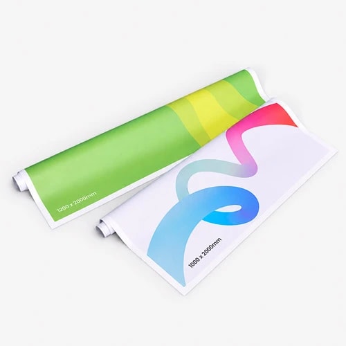 Two rolled posters with colourful abstract designs displayed on a plain gray background.