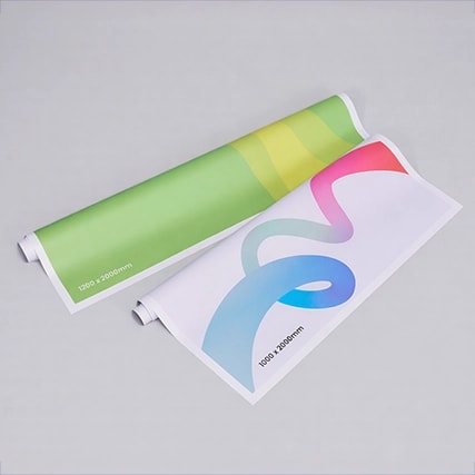 Two rolled posters with colorful abstract designs displayed on a plain gray background.