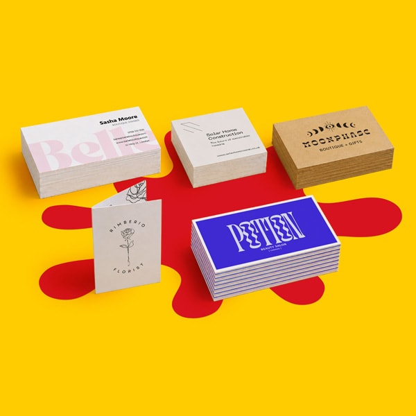 Five stacks of business cards with different designs on a yellow surface with a red shape.