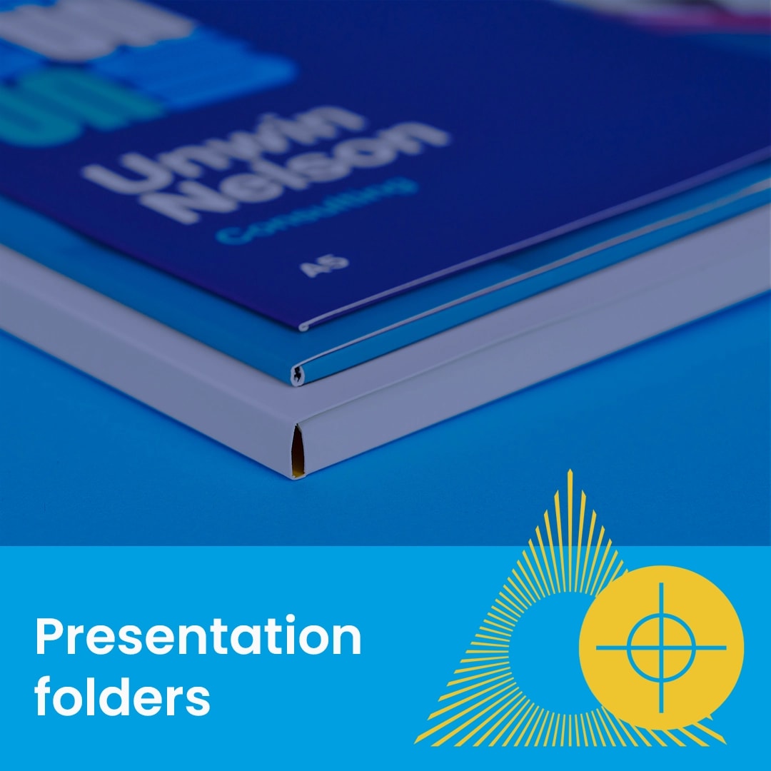 Close-up of stacked presentation folders on a blue surface with text and geometric graphics.