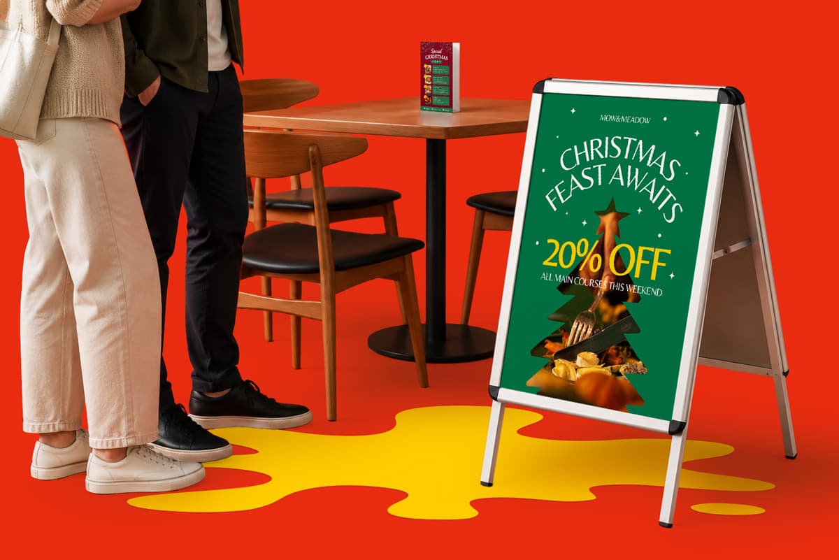 Two people stand near a restaurant sign advertising 20% off for a Christmas feast.