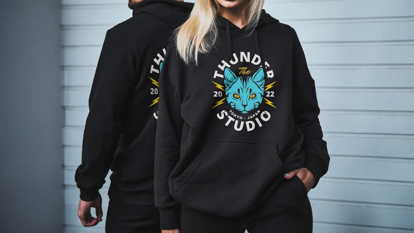 A man and woman in matching hoodies featuring the words "thunder cats," showcasing a casual and stylish look.