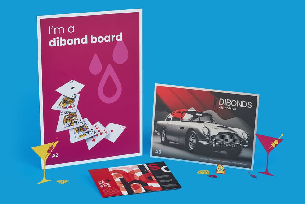 Various printed posters and cards displayed upright and flat on a blue background.