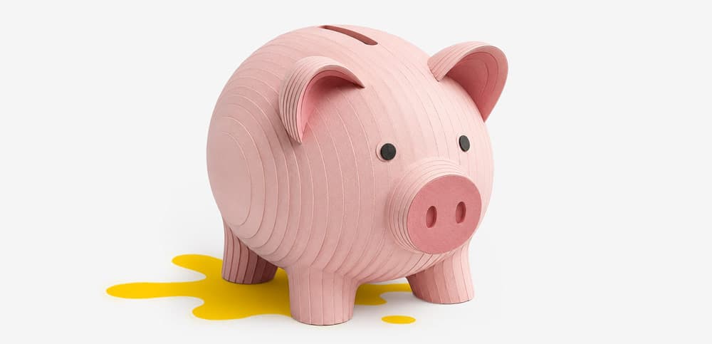 A pink paper piggy bank with a coin slot on top, shown on a plain white background.