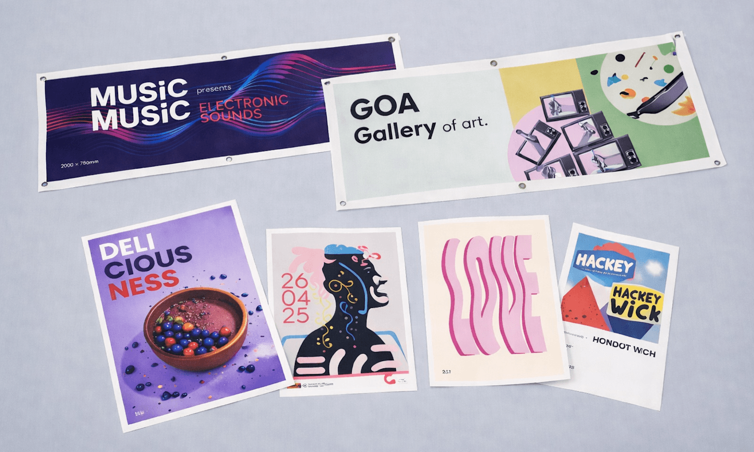 Six colourful, modern event and art posters displayed on a wide, light grey surface.