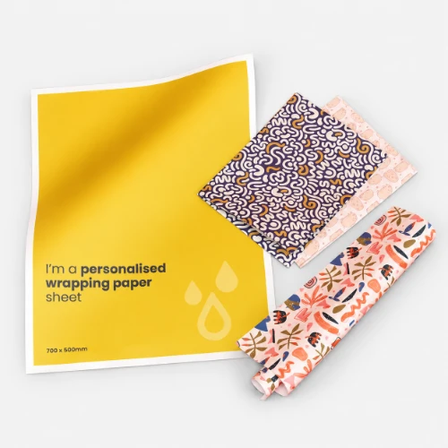 A yellow sheet of wrapping paper next to two patterned paper rolls.