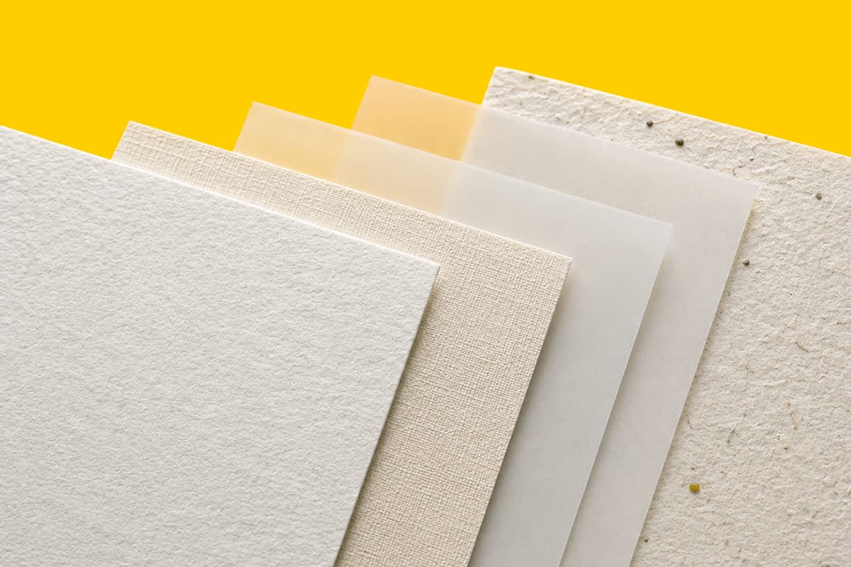 Five textured and translucent paper sheets arranged in a fan pattern on a yellow background.
