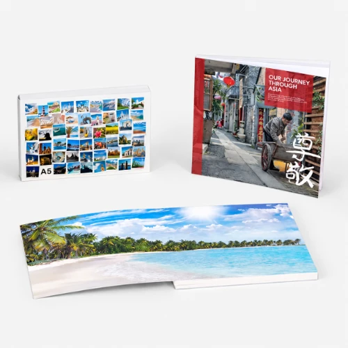 Three photo books, one open, featuring travel and scenic images on their covers and pages.