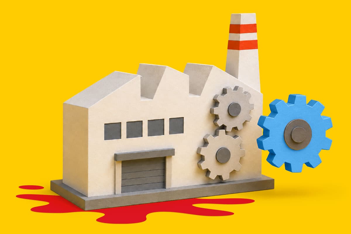 Cardboard factory model with gears and red liquid pooling beneath, set against yellow background.