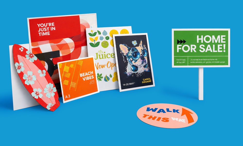 A variety of colourful printed signs and posters displayed on a blue surface.